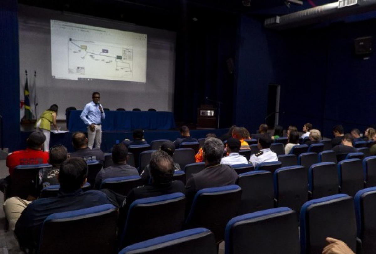 Palestra em auditório com apresentação de slides para um grupo de pessoas.