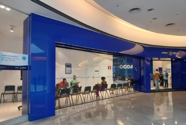 Unidade de atendimento do CODAU com clientes sentados na sala de espera e outros sendo atendidos.