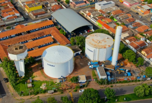 Vista aérea de uma unidade industrial com grandes silos da Codau, cercada por áreas residenciais e vias urbanas.