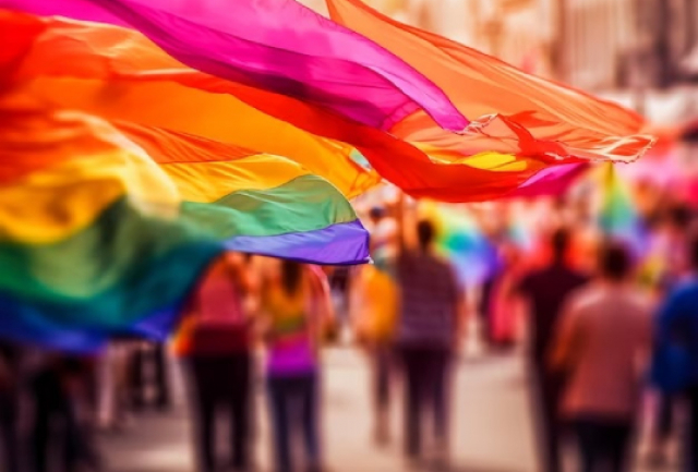 A imagem retrata uma cena vibrante no que parece ser uma Parada do Orgulho ou celebração LGBTQ+